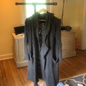 Calf length sweater with pockets and a hood.